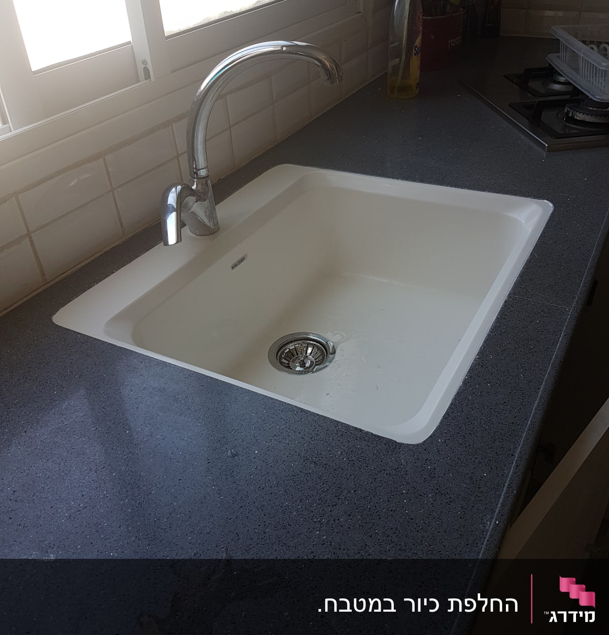 שיש כהה עם כיור לבן וברז מתכת מבריק